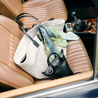 Handbags on a car seat with a focus on style and design.