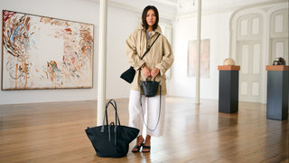 Woman holding a black handbag in an art gallery setting